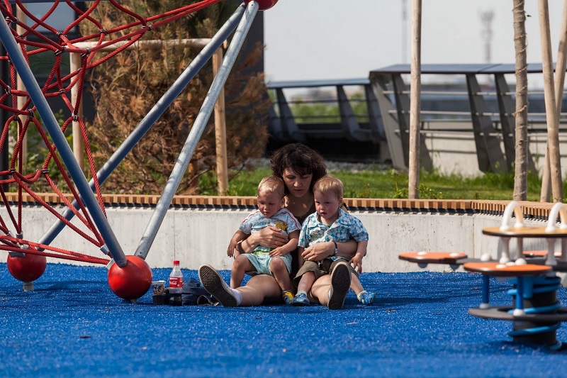 Женщина с двумя детьми на площадке